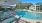 a pool with lounge chairs around it