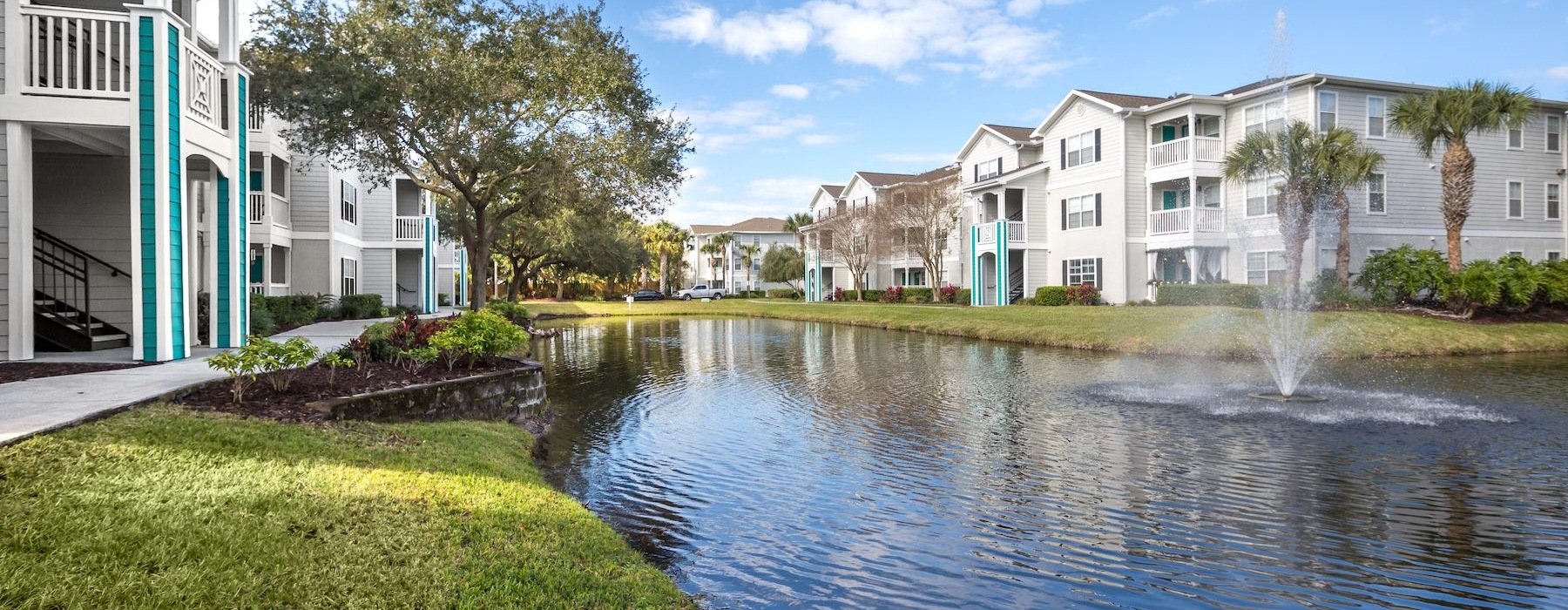 a pond with a fountain in an apartment community