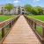 a wooden bridge over water leading to a building